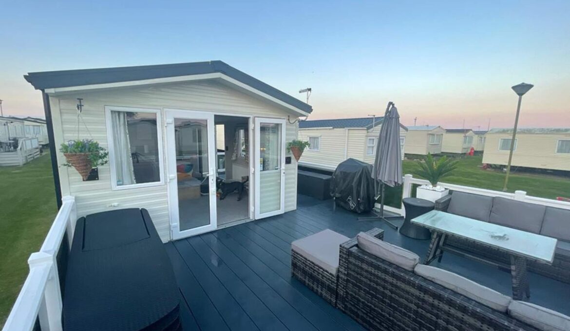 The Beach holiday caravan at New Beach Holiday Park, Dymchurch, with its XXL wraparound decking at dusk